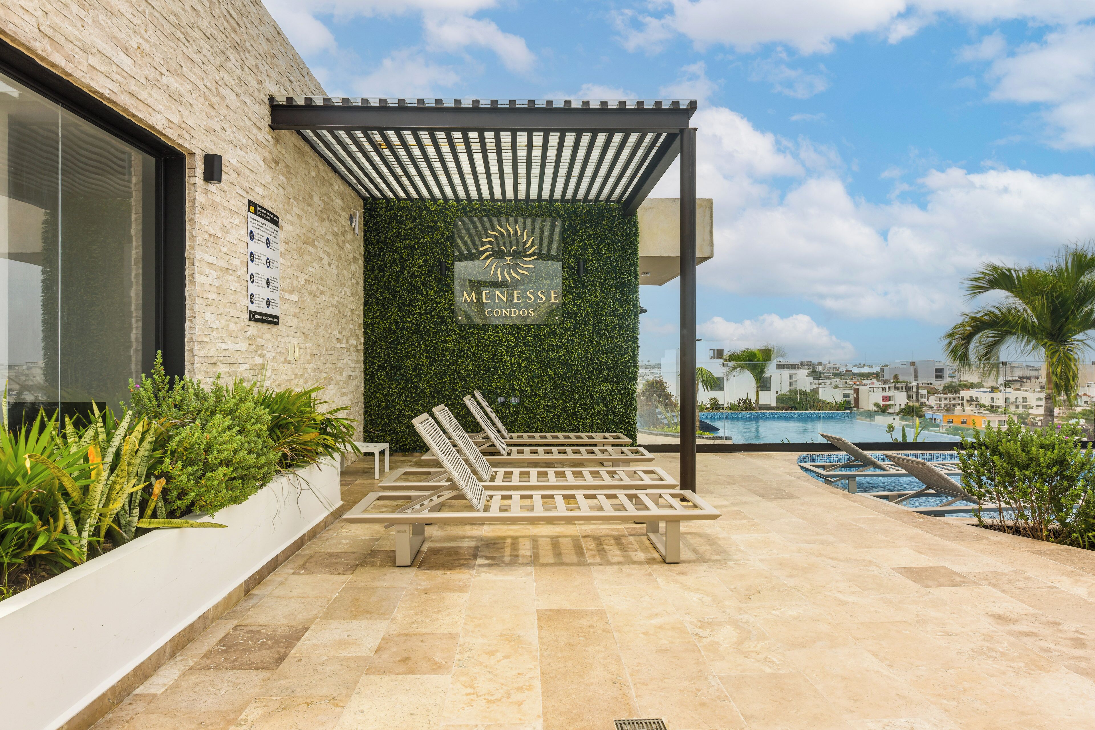 A modern outdoor seating area with a pergola, a pool, and a view of the cityscape.