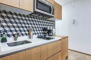 Eine moderne Küche mit Mikrowelle, Spüle und Kaffeemaschine.
