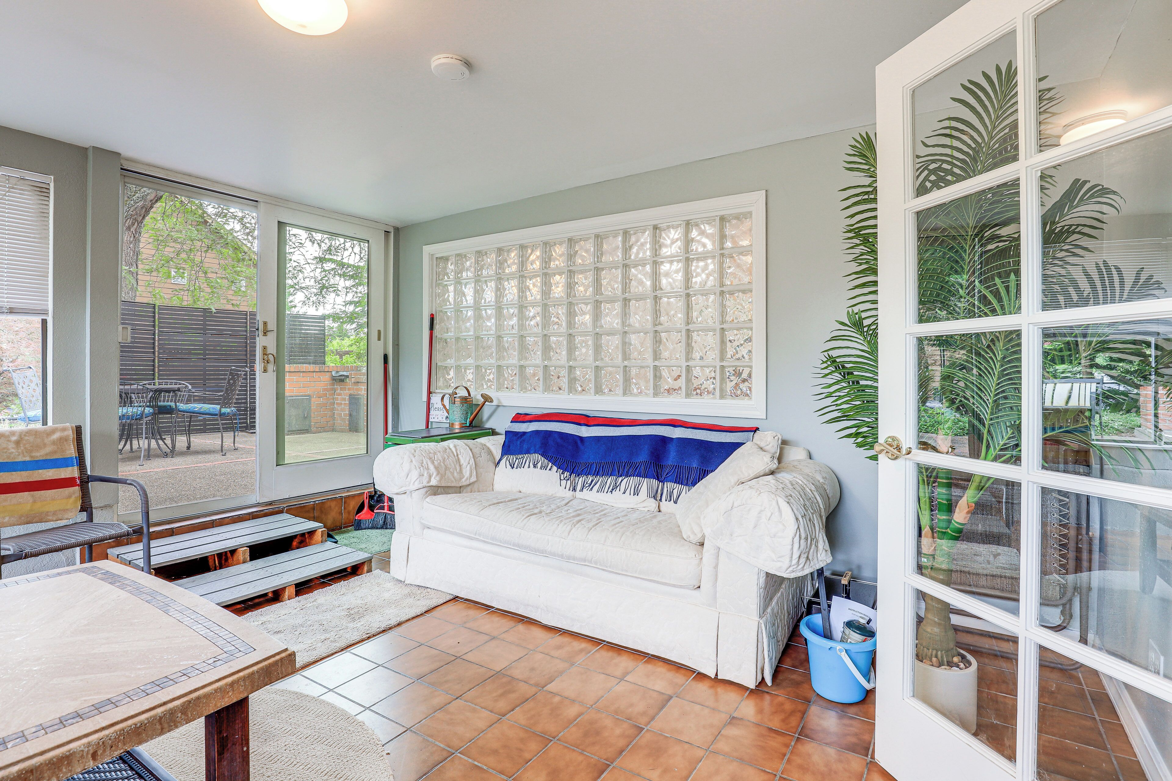 Una sala de estar acogedora con un sofá blanco, una mesa de centro y una zona de comedor con una silla y una mesa.