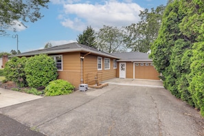 A single-story house with a garage, a small front yard, and a driveway. - Unique Unit w/ Patio & Grill in Portland Area! (Milwaukie)