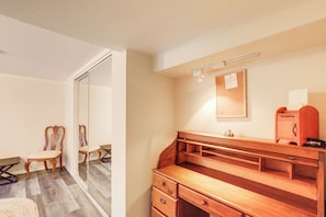 A room with a wooden desk, a chair, a mirror, and a corkboard on the wall. - Unique Unit w/ Patio & Grill in Portland Area! (Milwaukie)