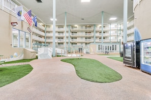 A multi-level indoor atrium with a central pathway, artificial grass, vending machines, and flags. - Pool Access! Family Getaway in Hilton Head Resort (Hilton Head Island)