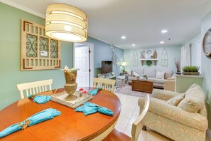 A dining area with a wooden table, chairs, and a hanging light fixture. - Pool Access! Family Getaway in Hilton Head Resort (Hilton Head Island)