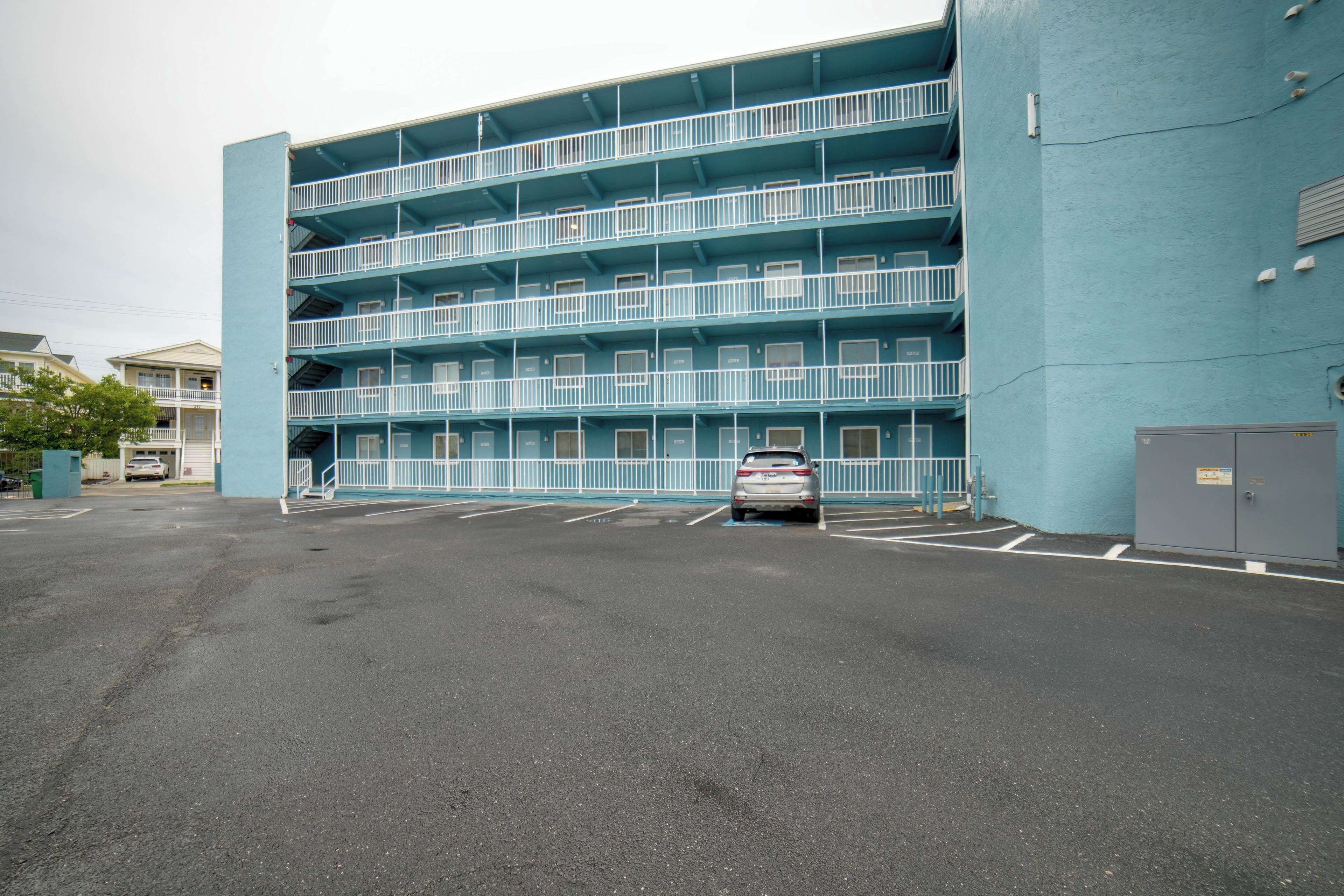 Un parking à plusieurs étages, avec un immeuble bleu situé à côté.