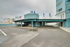 A multi-story building with a covered walkway, outdoor seating, and a parking area. - 2 Block to Beach & Boardwalk! Wildwood Studio (Wildwood)