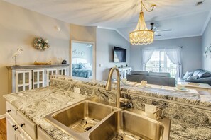 A kitchen with granite countertops, stainless steel sink, and a chandelier. - Waterfront Condo w/ Views & Pool in Little River (Little River)