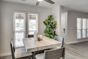 A dining area with a table, chairs, a ceiling fan, and a large plant. - 1 Mi to Unlv & Strip! Modern Vegas Condo (Las Vegas)