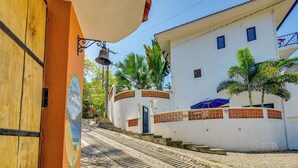 A guesthouse with a wooden door, a bell, and a sign indicating it's a guesthouse. - Walk to Beach & Dining! Chic San Pancho Casita (San Francisco)
