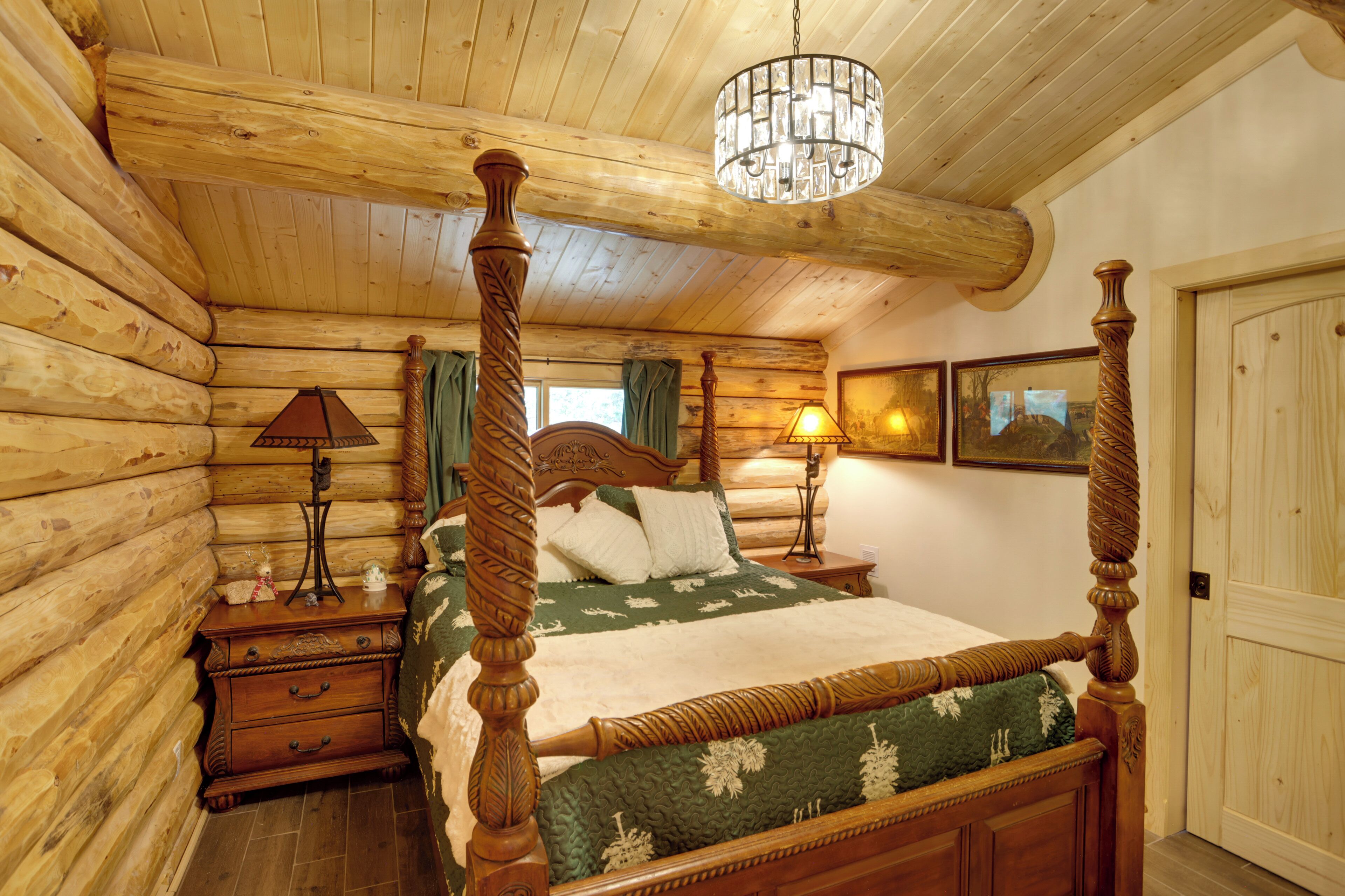 Une chambre dans une cabane en rondins, avec un lit à baldaquin, des murs en bois et un lustre.