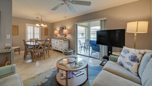 A living room with a ceiling fan, a TV, a dining area with a table and chairs, and a sofa. - Golf On-site! Extended Stay 4 Mi to Dtwn Naples (Naples)