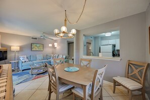 A dining area with a wooden table and chairs, a sofa, a coffee table, and a chandelier. - Golf On-site! Extended Stay 4 Mi to Dtwn Naples (Naples)