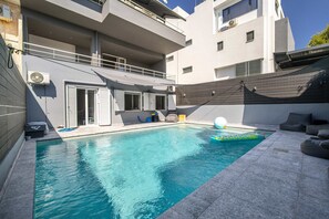 A swimming pool with a built-in slide, a covered seating area, and a balcony. - K K Villa in Athens Riviera With Private Pool (Vari-Voula-Vouliagmeni)