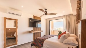 Een moderne slaapkamer met een bed, een plafondventilator, een wandgemonteerde televisie en een groot raam.