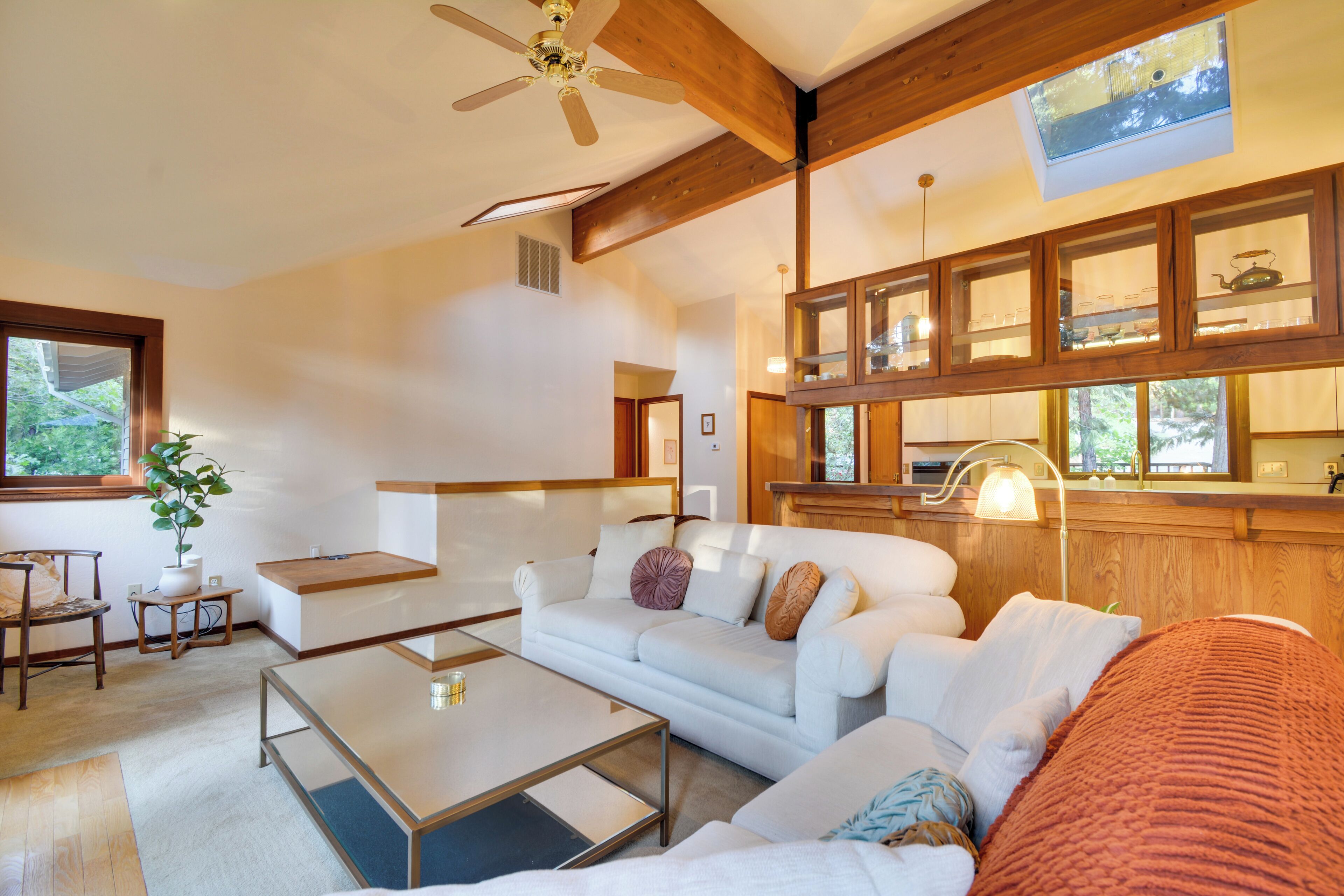 A modern living room with a sofa, coffee table, and a ceiling fan.