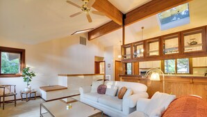 Una sala moderna con sofá, mesa de centro y ventilador de techo.