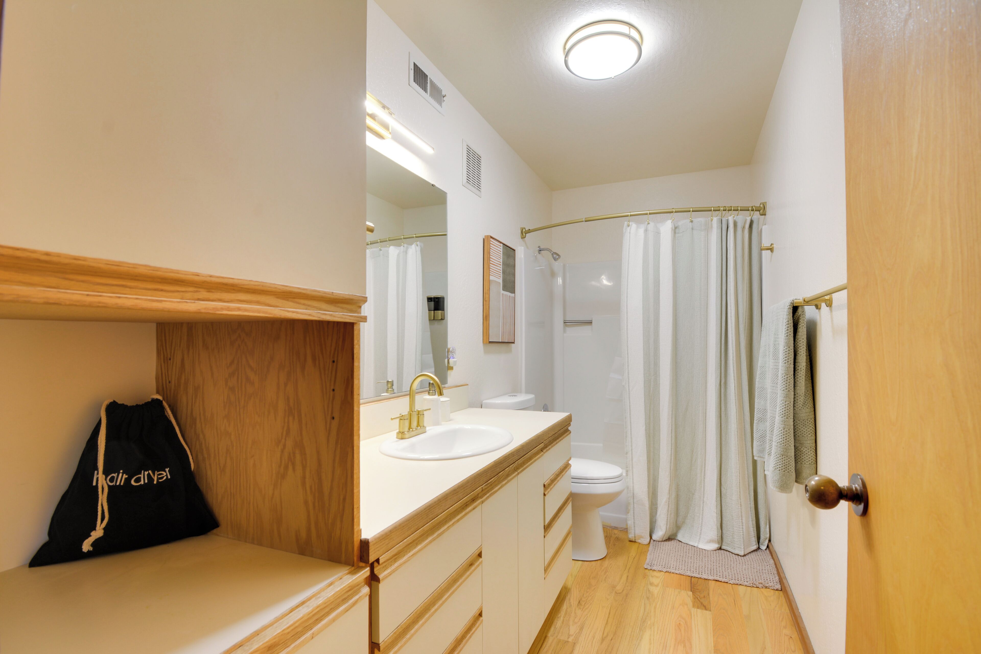 A bathroom with a sink, toilet, and shower curtain.