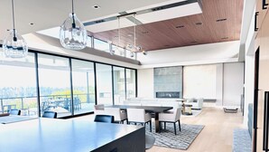 Una cocina moderna con una isla grande, comedor y vistas al exterior.