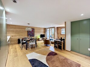 Ein modernes Interieur mit Essbereich, Fernseher und großem Kleiderschrank.