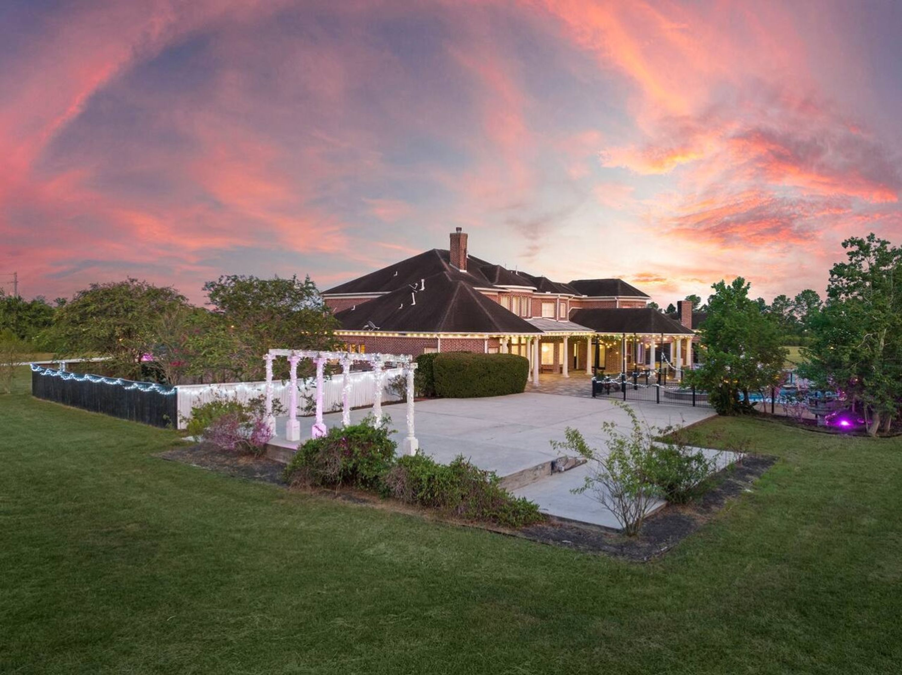 A large, two-story building with a covered patio area and a well-maintained lawn.