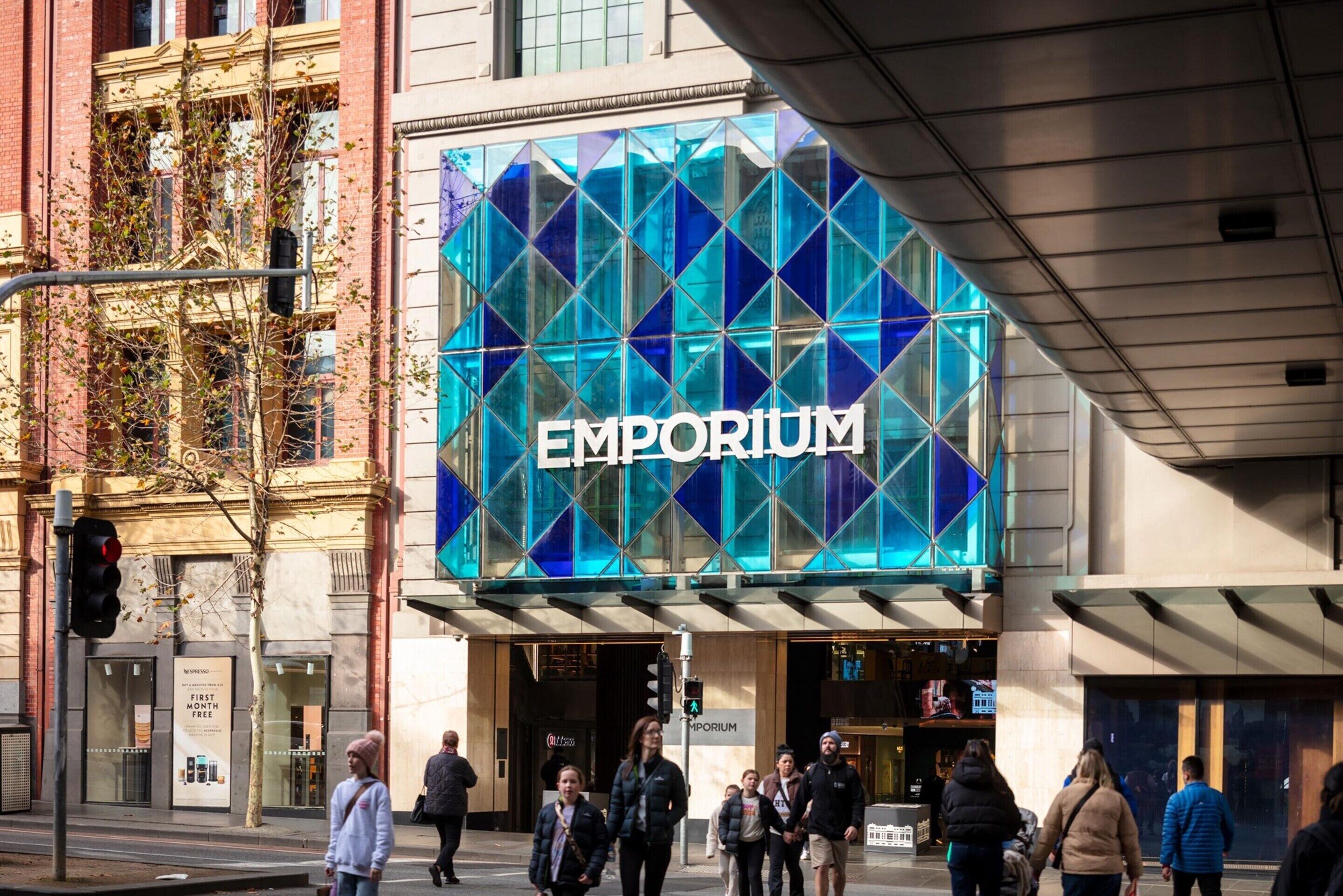 Ein Gebäude mit einem auffälligen 'EMPORIUM'-Schild, einer modernen Glasfassade und einem Eingang im Erdgeschoss.