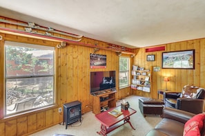 A wooden-paneled room with a television, a fireplace, a bookshelf, and a large window. - Year-round Mtn Escape in the 'arizona Rockies' (Lakeside)