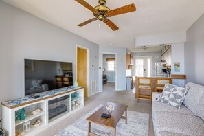 A living room with a TV, wooden coffee table, and a sofa. - Bayfront Condo w/ Sunset Views! Walk to Beach (Seaside Heights)