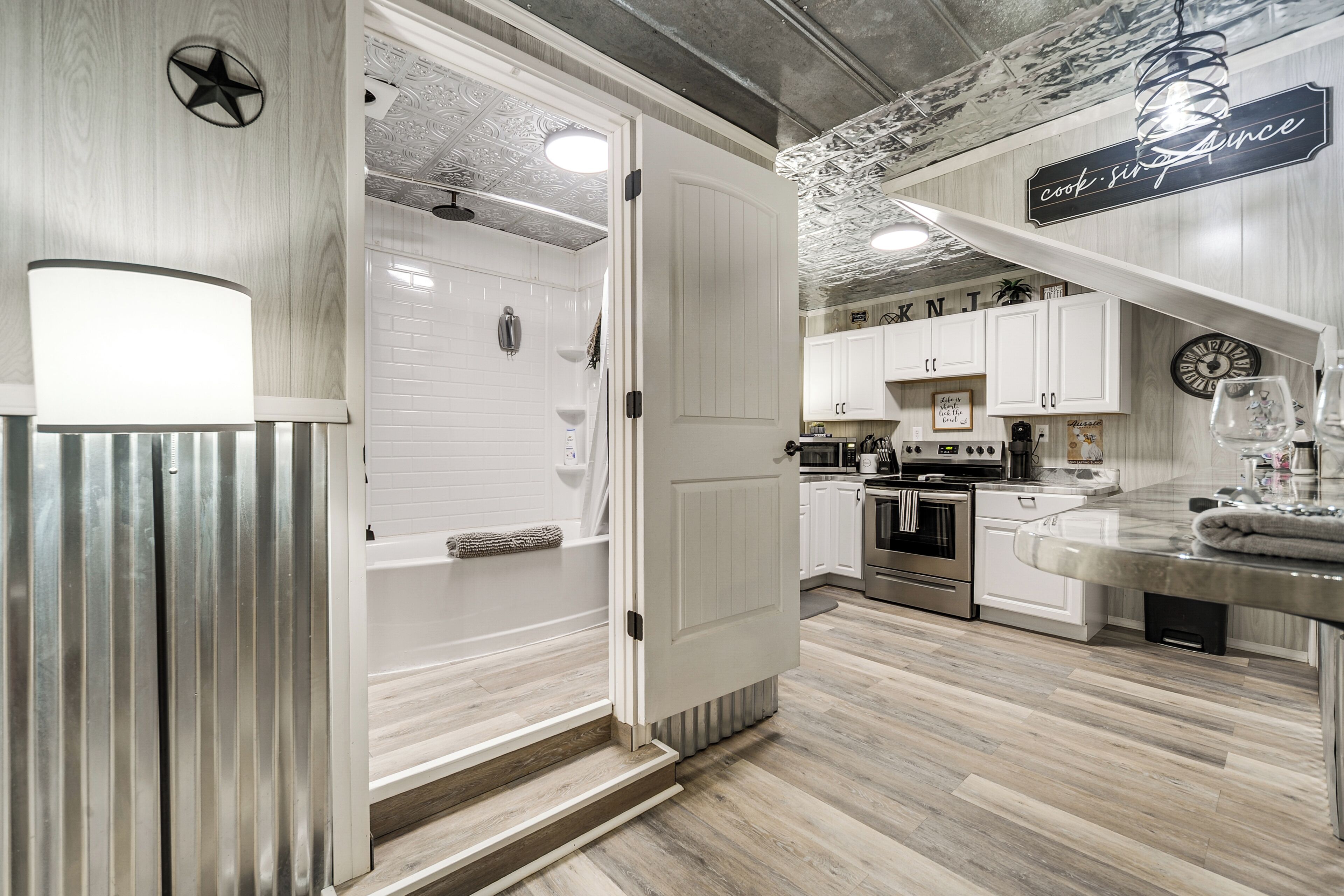 A modern kitchen with white cabinetry, a built-in oven, and a countertop with a sink.