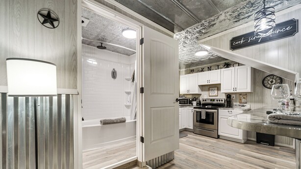 A modern kitchen with white cabinetry, a built-in oven, and a countertop with a sink. - Fredericksburg Barn w/ Balcony: Sip, Soak + Hike (Fredericksburg)