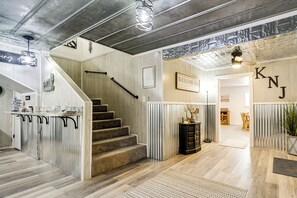Ein modernes Interieur mit Treppe, Holzboden und einer Willkommensschild.