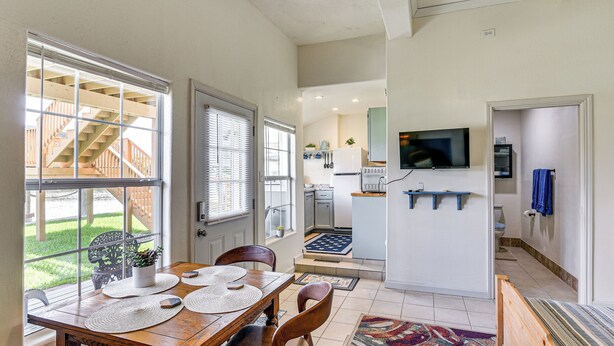 A dining area with a wooden table, chairs, and a view of a wooden deck outside. - Waterfront Studio w/ Dock, 8 Mi to Kemah Boardwalk (Dickinson)