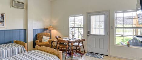 A bedroom with two beds, a desk, and a chair.