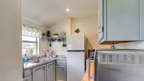 A kitchen with a refrigerator, microwave, sink, and cabinets. - Waterfront Studio w/ Dock, 8 Mi to Kemah Boardwalk (Dickinson)