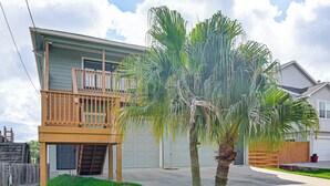 A two-story house with a balcony, a garage, and a lawn with palm trees. - Waterfront Studio w/ Dock, 8 Mi to Kemah Boardwalk (Dickinson)