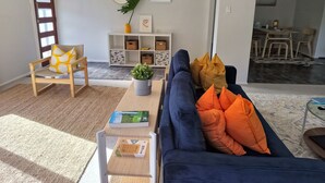Ein Wohnzimmer mit einer Couch, einem Sessel, einem Couchtisch und einem Bücherregal.
