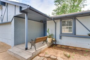 A house with a porch, a bench, a potted plant, and a window. - Bring Your Pets! Family-friendly Escape in Edmond (Edmond)