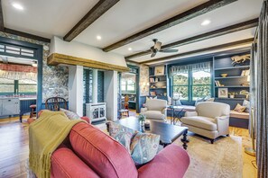 A cozy living room with a fireplace, a dining area, and a bookshelf.