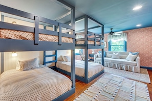 Une chambre avec des lits superposés, un canapé et une grande fenêtre donnant sur un beau paysage.