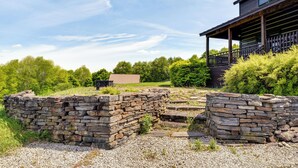 A stone wall, a wooden deck, and a building with a porch. - 95-acre Countryside Estate! Luxe Vermont Farmhouse (Chelsea)
