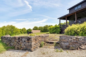 A stone wall, a wooden deck, and a building with a porch. - 95-acre Countryside Estate! Luxe Vermont Farmhouse (Chelsea)