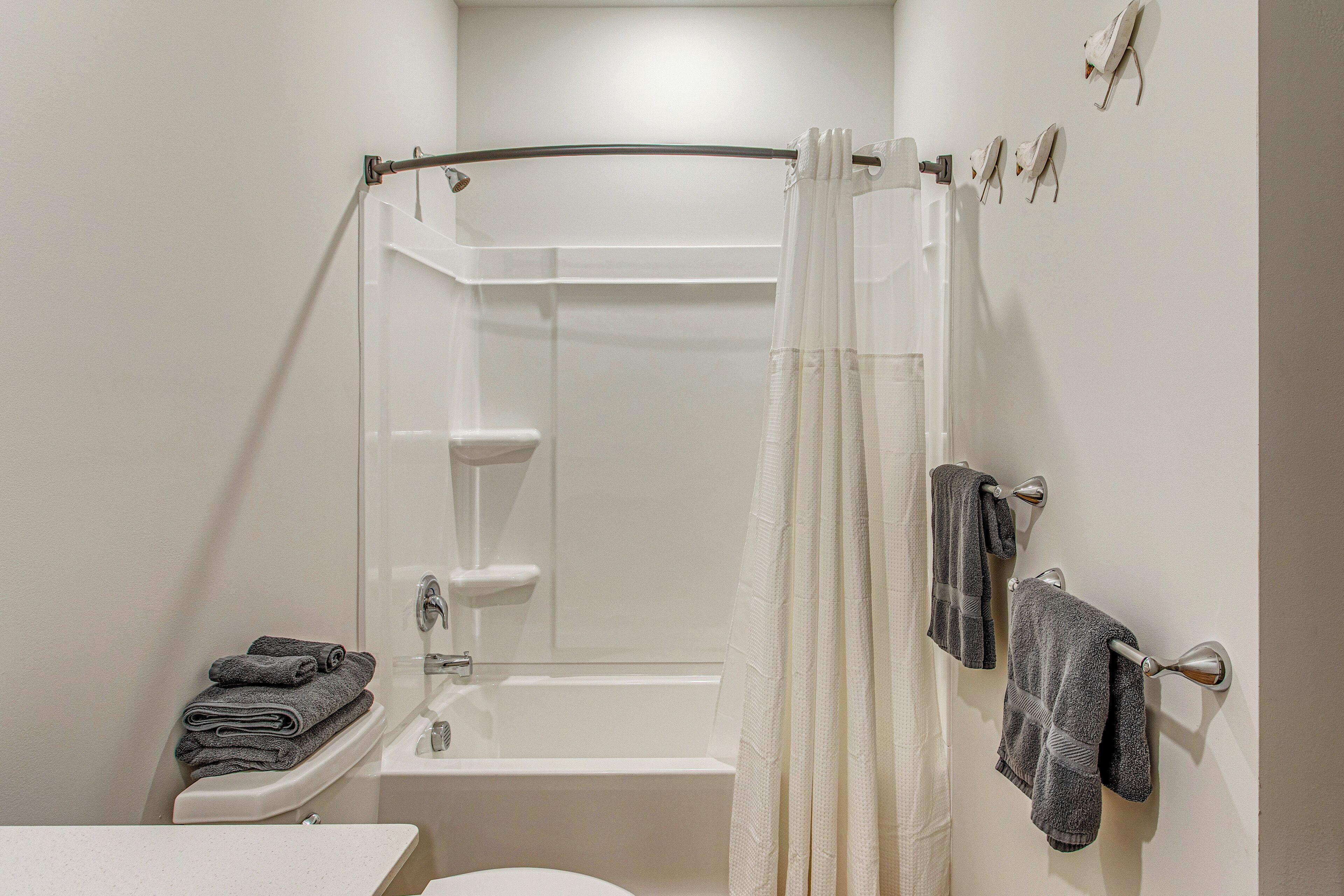 Ein Badezimmer mit Badewanne, Toilette, Waschbecken und Duschvorhang.