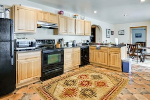 A kitchen with wooden cabinets, a microwave, stove, and a coffee maker.