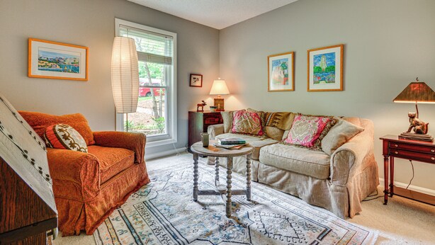 A living room with a sofa, a coffee table, and a lamp. There are framed pictures on the walls. - 1 Mi to Science Center & Park! Pet-friendly Haven (Greensboro)