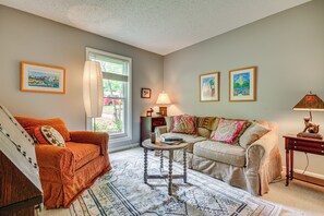A living room with a sofa, a coffee table, and a lamp. There are framed pictures on the walls. - 1 Mi to Science Center & Park! Pet-friendly Haven (Greensboro)