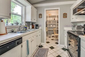 A kitchen with white cabinets, a dishwasher, a coffee maker, and a toaster. - 1 Mi to Science Center & Park! Pet-friendly Haven (Greensboro)