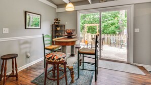 A dining area with a round table, chairs, and a view through a glass door to an outdoor patio. - 1 Mi to Science Center & Park! Pet-friendly Haven (Greensboro)