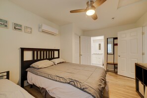 A bedroom with a bed, a ceiling fan, an air conditioning unit, and a door leading to another room. - Bring Your Pets! Convenient Home in Riverside (Riverside)