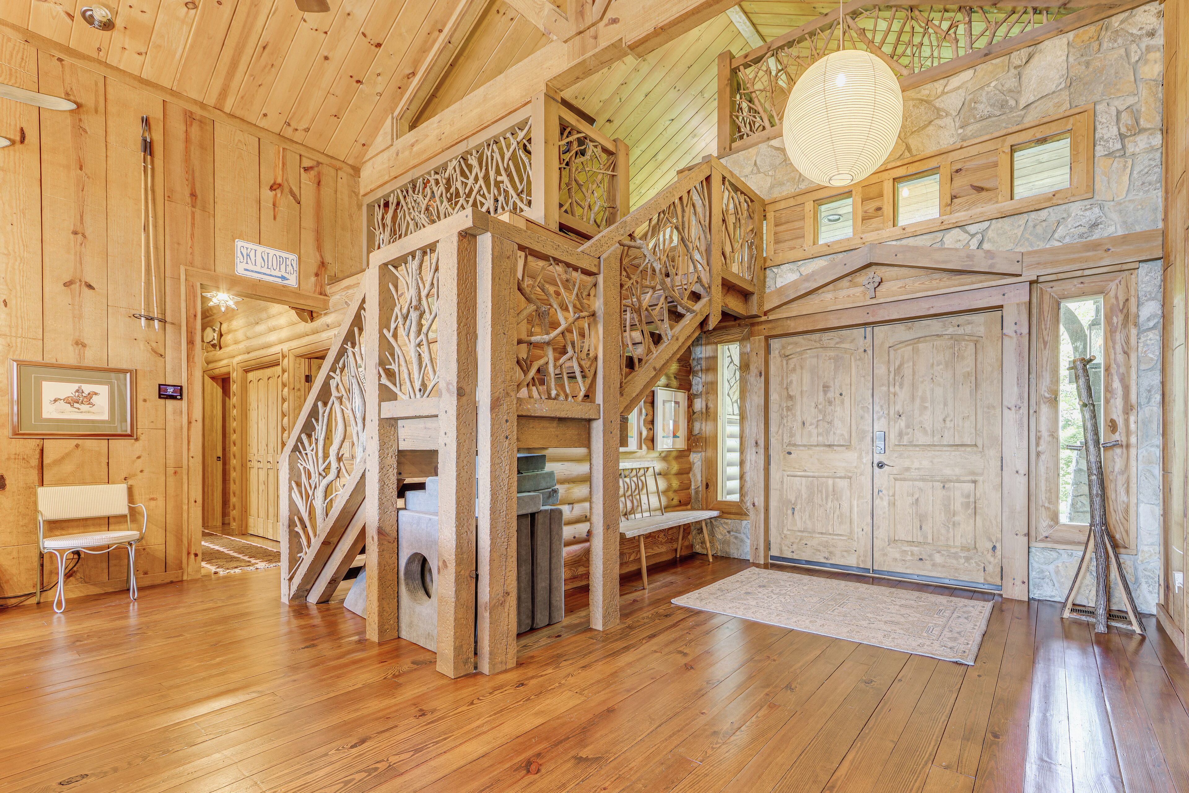 A wooden cabin interior with a staircase, wooden walls, a bench, and a sign reading 'Ski Slopes'.