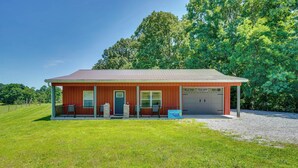 A single-story building with a red exterior, a covered porch, and a garage. - Boaters Base! 11 Mi to Kentucky & Barkley Lakes (Grand Rivers)