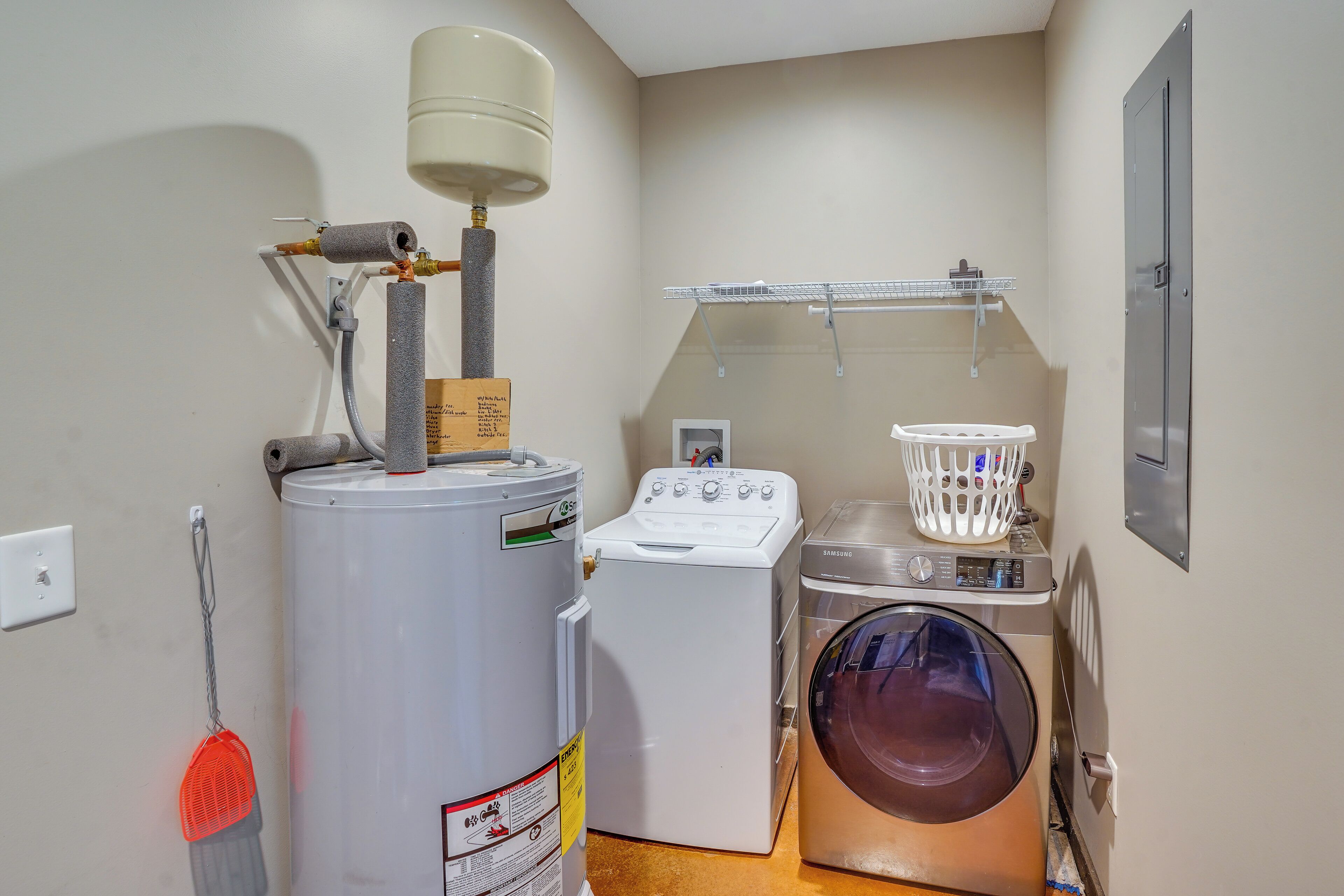 A laundry room with a washer, dryer, and a water heater.