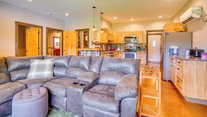 A modern kitchen with wooden cabinets, a stainless steel refrigerator, and a dining area with a wooden table and chairs. - Boaters Base! 11 Mi to Kentucky & Barkley Lakes (Grand Rivers)